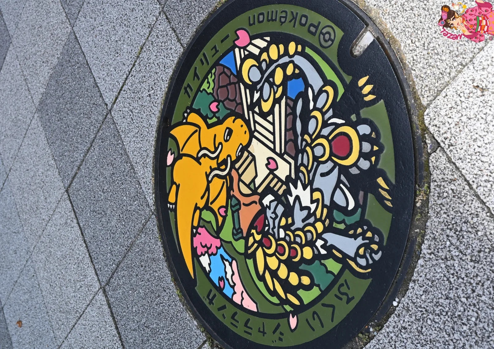 Plaque d'&eacute;gout Pok&eacute;mon &agrave; l'effigie de Dracolosse, dans une rue de Fukui