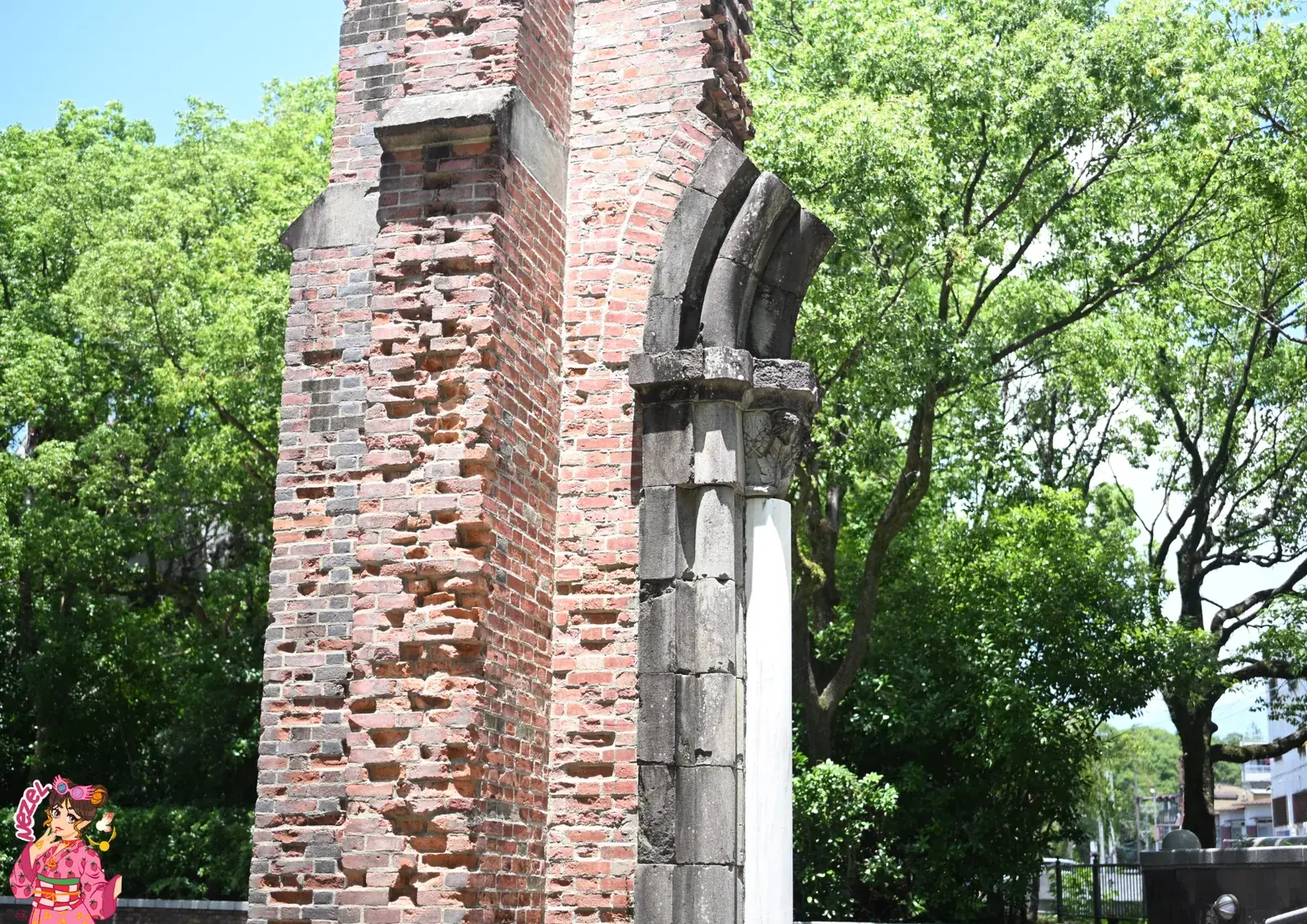 Arche de pierre rescapée de la cathédrale d'Urakami, adossée à un pan de mur en brique