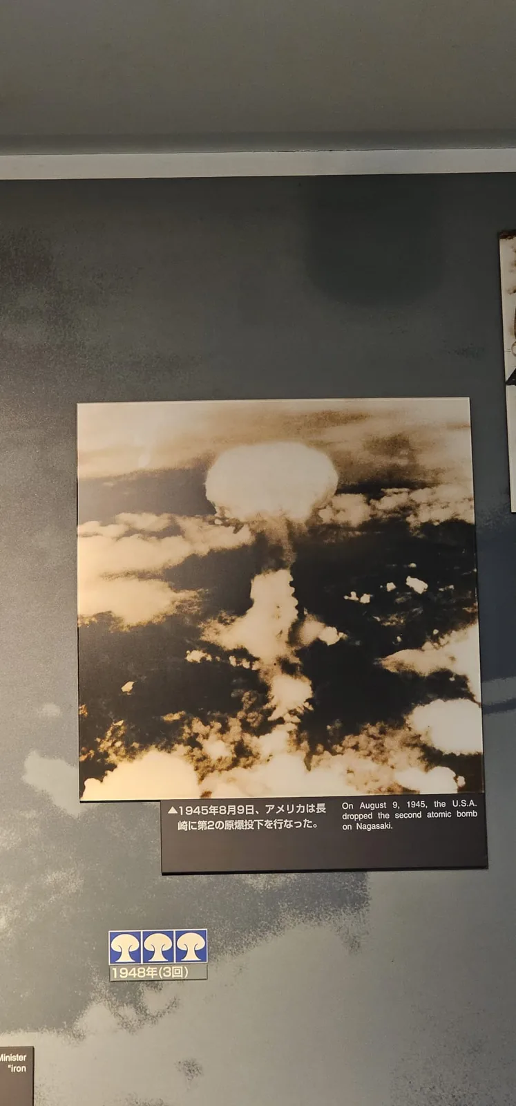 Photographie d'archive du champignon atomique au-dessus de Nagasaki, exposée au musée, avec sa légende : « On August 9, 1945, the U.S.A. dropped the second atomic bomb on Nagasaki »
