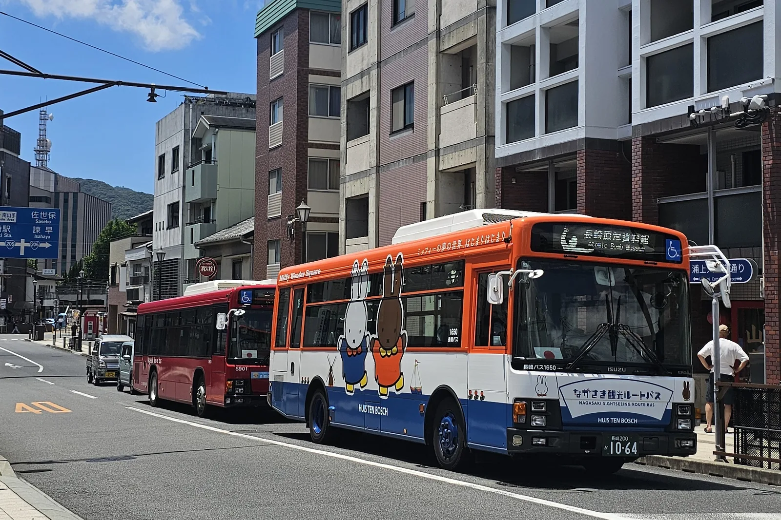 Bus de ville orange et blanc à l'arrêt dans une rue japonaise