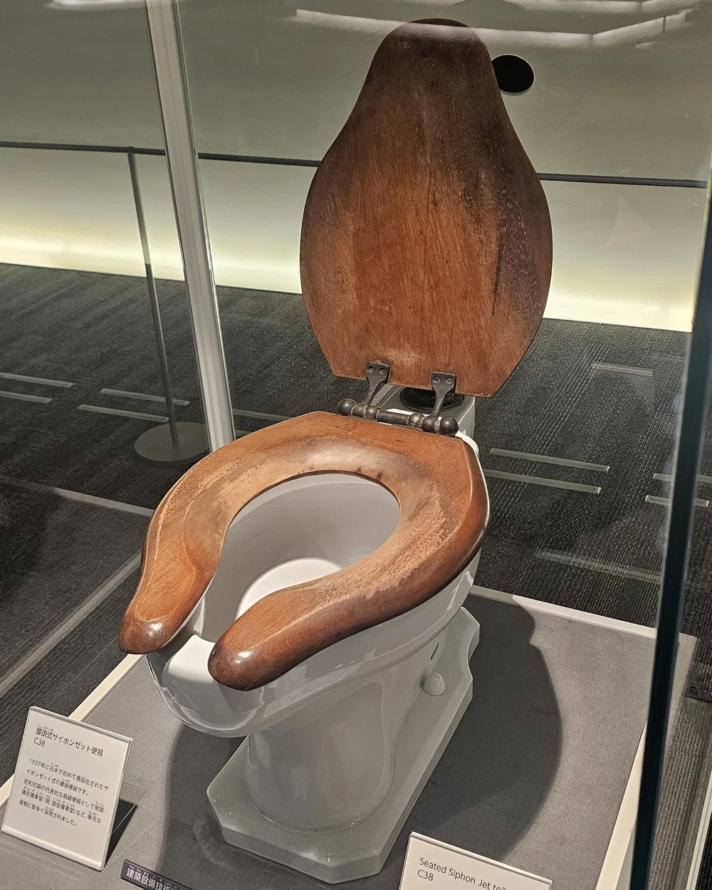 Toilettes en céramique blanche à siège et abattant en bois massif, modèle C38, sous vitrine au TOTO Museum